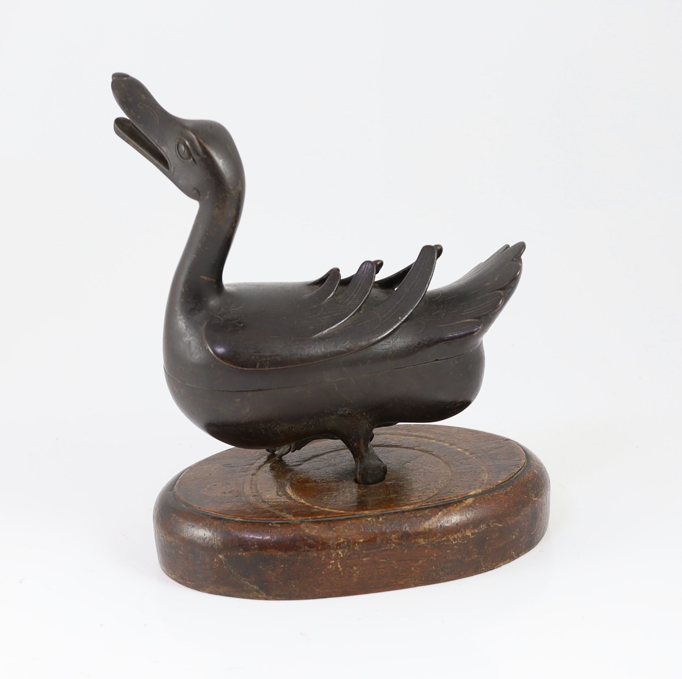 A Chinese Ming bronze ‘duck’ censer and cover, 17th century, 24.5cm long, missing one foot and later inset wood stand